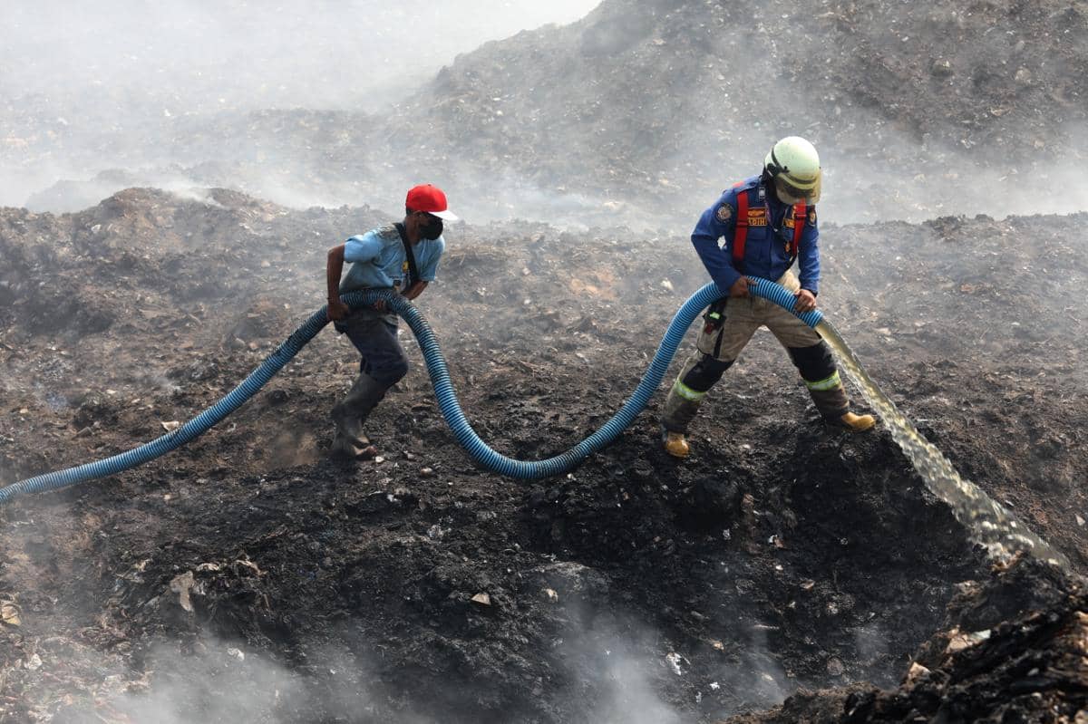 Personil gabungan berjibaku memadamkan api kebakaran TPA Jatiwaringin, Tangerang dengan menggunakan semprotan air pada Senin (6/7).