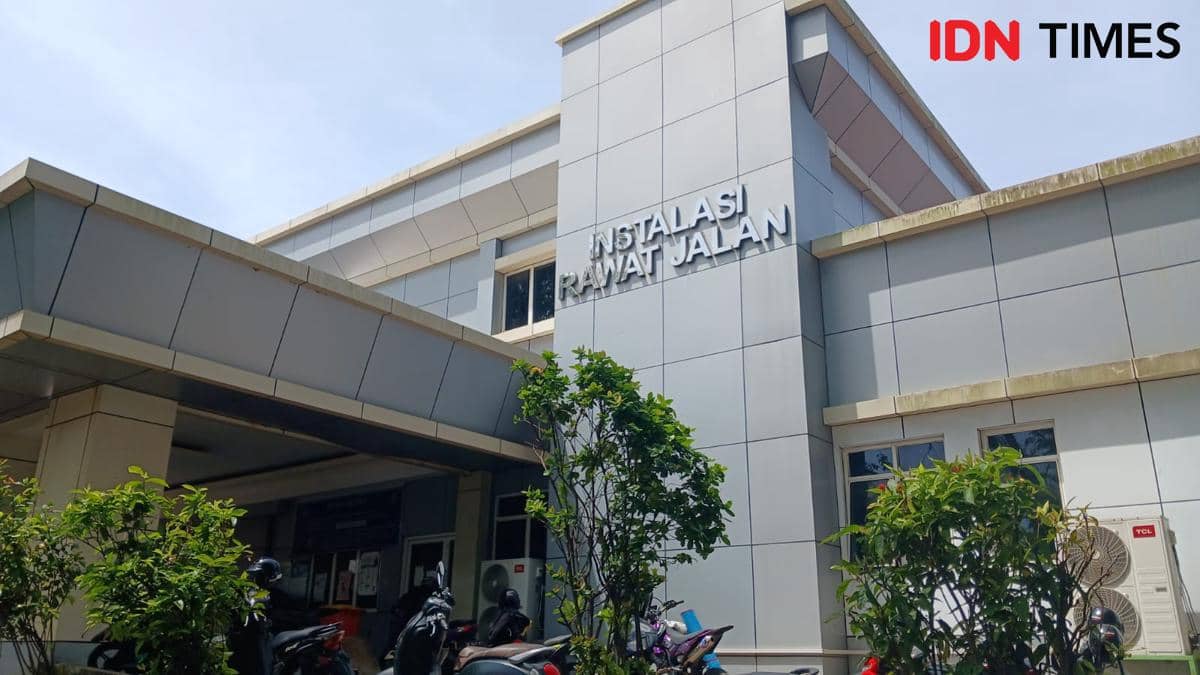 Tampak depan gedung Instalasi Rawat Jalan RSUP Kandou di Manado, Sulawesi Utara dengan beberapa kendaraan terparkir di depannya.