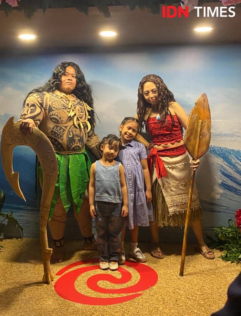 Seorang artis berpose bersama keluarganya di acara special screening film Moana live-action di Jakarta dengan latar bertema laut.