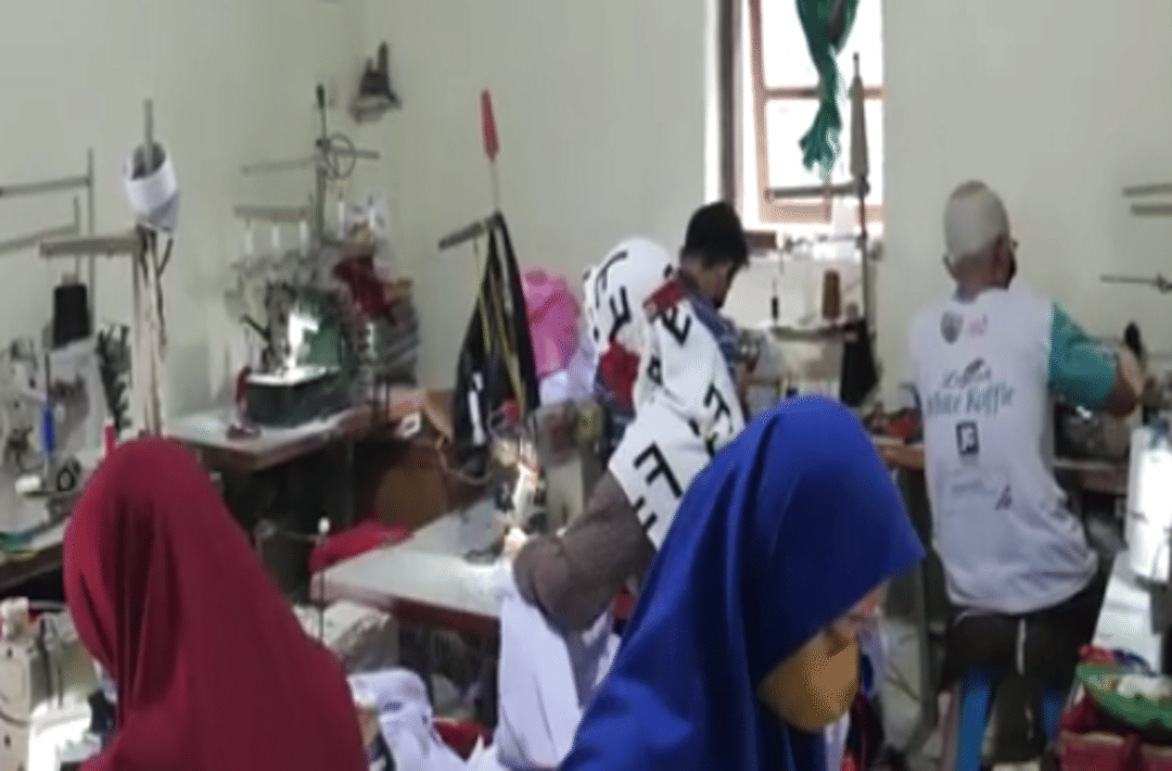 Beberapa penjahit bekerja di dalam ruangan dengan mesin jahit untuk memenuhi pesanan seragam sekolah di Banyumas.