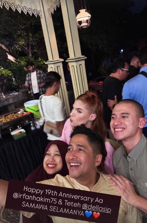 Beberapa orang tersenyum dan berfoto bersama dalam perayaan ulang tahun pernikahan ke-19 di sebuah acara malam hari.