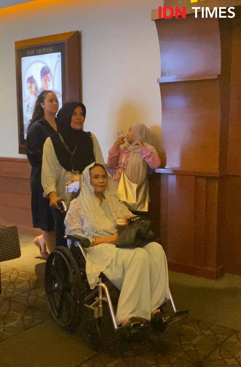 Seorang wanita lanjut usia duduk di kursi roda bersama keluarganya di acara special screening film Moana live-action di Jakarta.