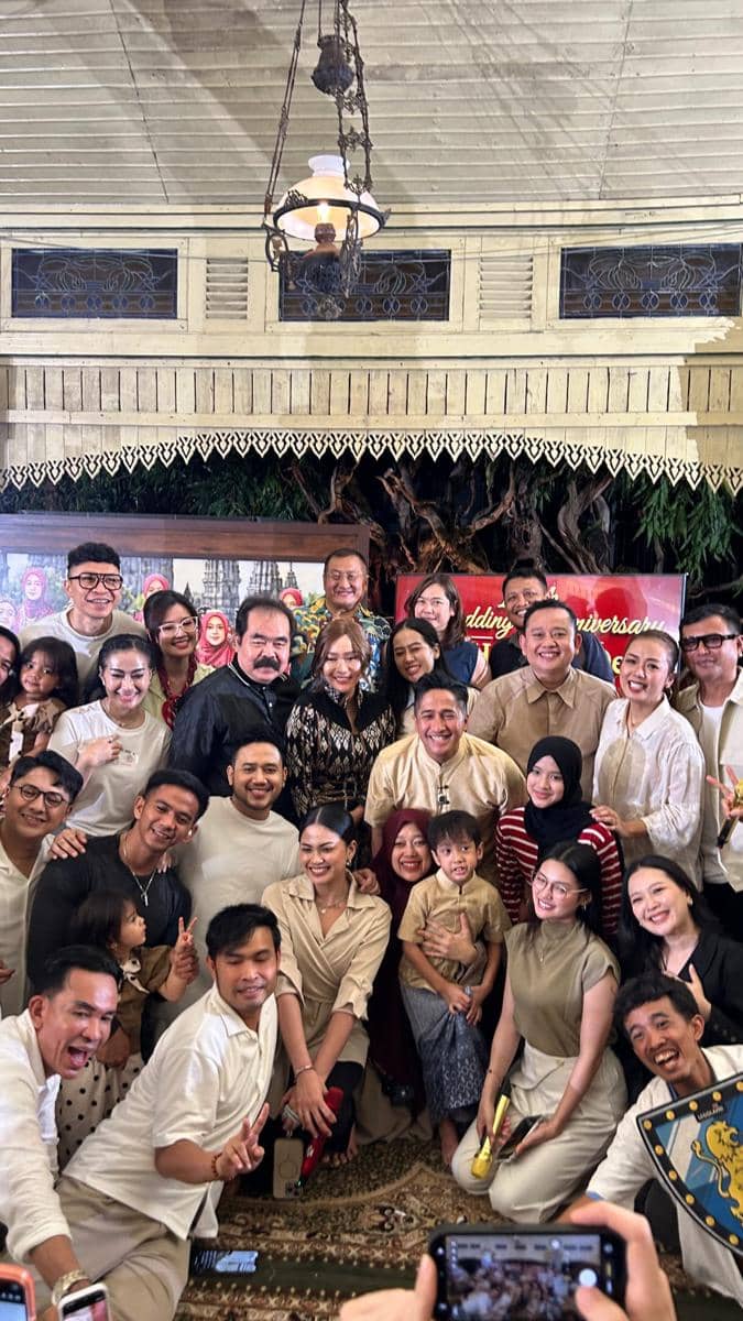 Sejumlah artis dan tamu berpose bersama dalam perayaan ulang tahun pernikahan ke-19 Irfan Hakim dan istri di sebuah ruangan bernuansa tradisional.