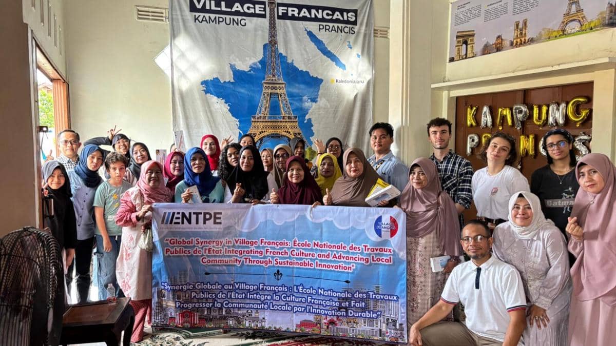 Anggota Komunitas Kampung Prancis di Kota Metro berpose bersama di depan spanduk bertema budaya Prancis dengan gambar Menara Eiffel.