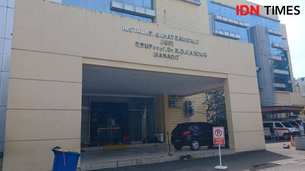 Tampak depan gedung Instalasi Gawat Darurat RSUP Prof. Dr. R.D. Kandou di Manado, Sulawesi Utara dengan area parkir dan mobil di depannya.