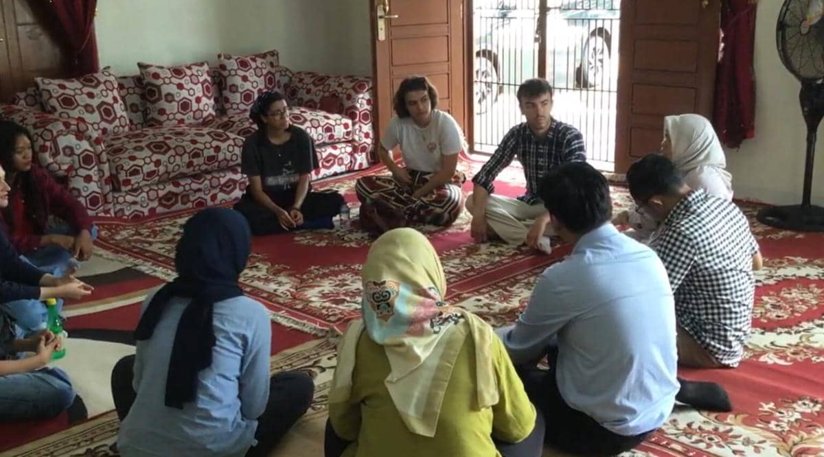 Beberapa anggota Komunitas Kampung Prancis di Kota Metro duduk melingkar di dalam ruangan berkarpet merah untuk berdiskusi santai.