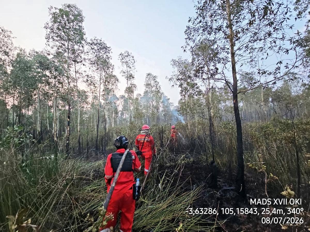 Petugas Manggala Agni mengenakan pakaian pelindung merah memadamkan kebakaran hutan dan lahan di kawasan berhutan Desa Pulau Geronggang, OKI.
