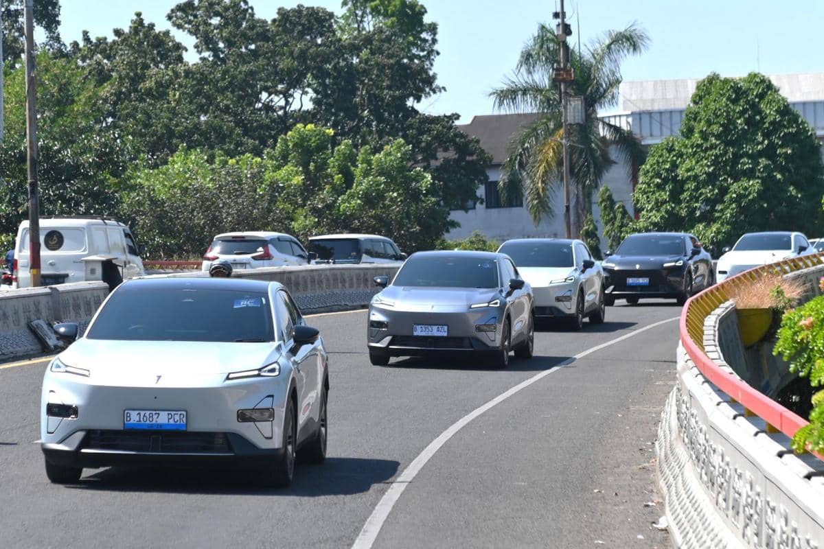 Beberapa mobil listrik Changan Deepal S05 melaju di jalan raya dengan latar pepohonan dan bangunan di siang hari.