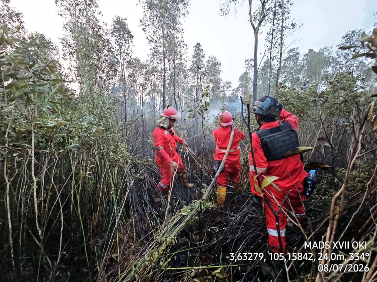 Petugas Manggala Agni Daops Sumatera XVII/OKI mengenakan pakaian pelindung merah saat memadamkan kebakaran hutan dan lahan di Desa Pulau Geronggang, OKI.