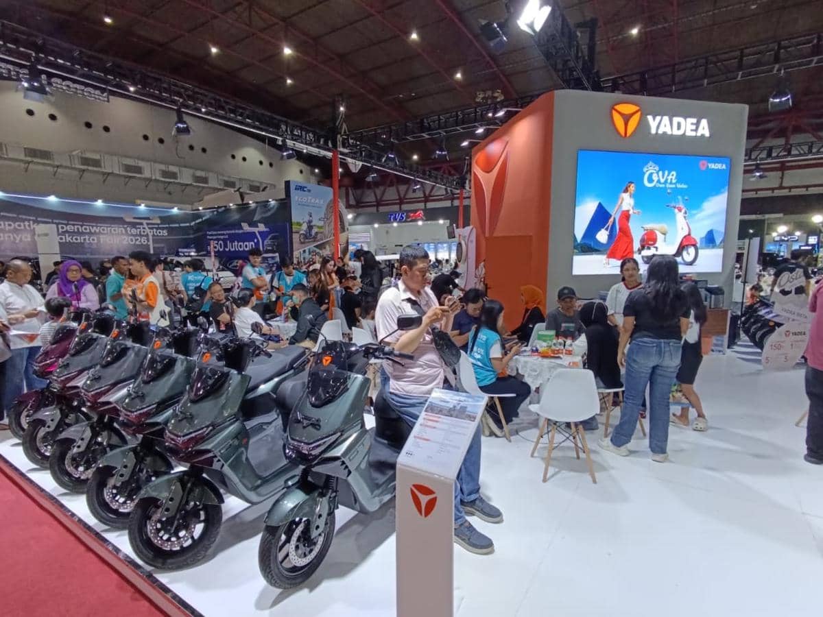 Pengunjung memadati stan Yadea yang memamerkan deretan motor listrik dan menawarkan berbagai skema pembiayaan di sebuah pameran otomotif.