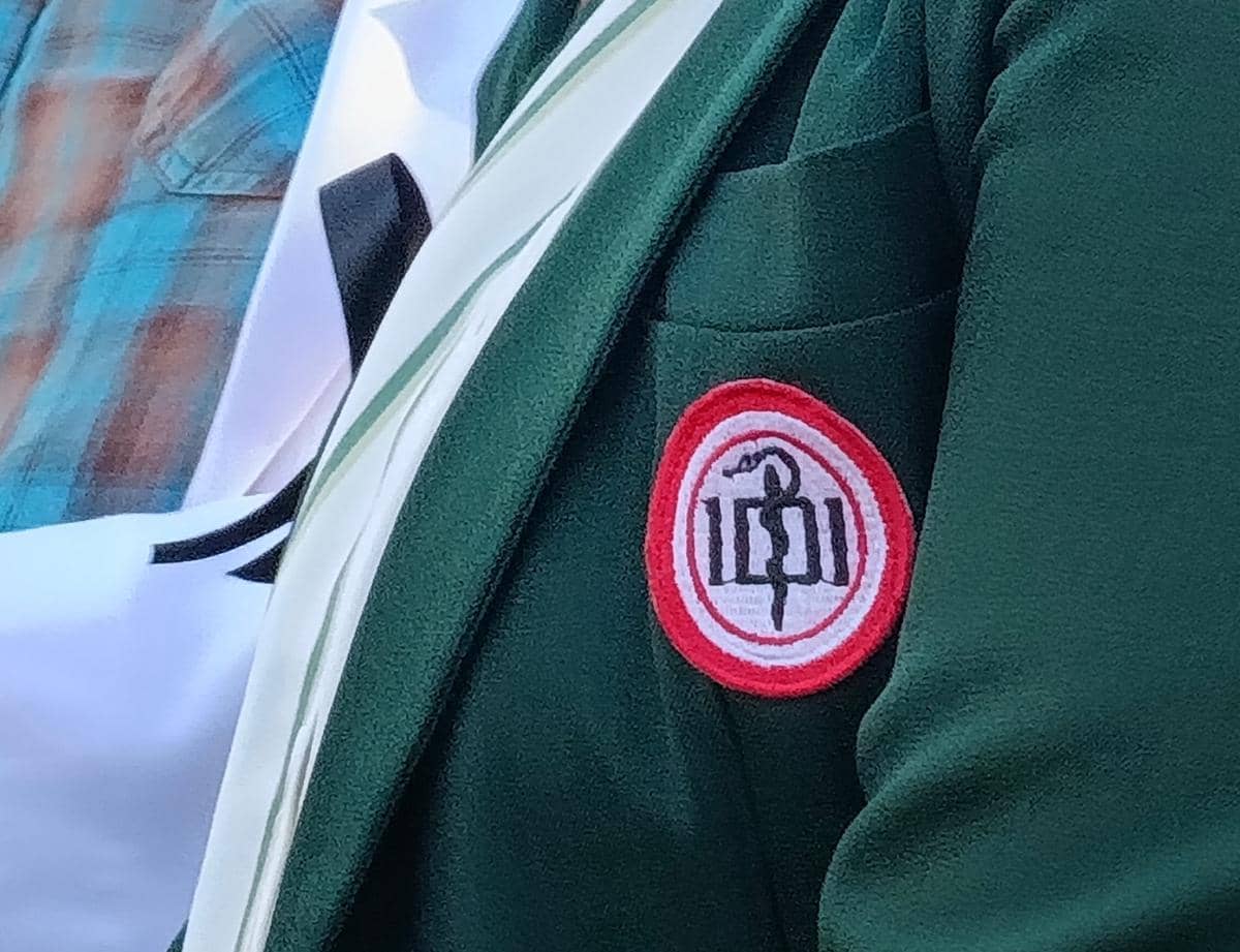 Logo Ikatan Dokter Indonesia berwarna merah putih terpasang di saku jas hijau yang dikenakan seorang anggota di Kupang.