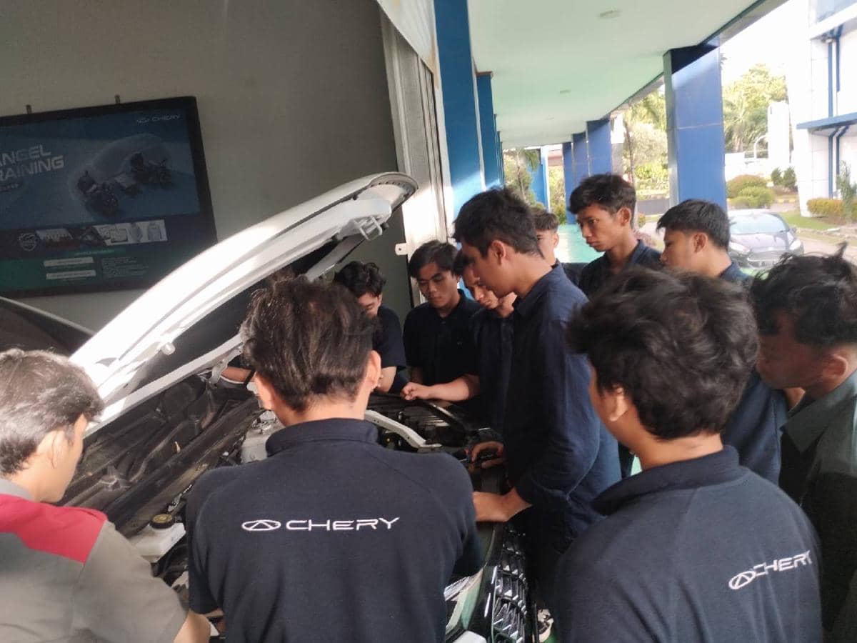 Beberapa teknisi Chery memeriksa kondisi mesin mobil di area servis untuk memastikan kendaraan dalam keadaan aman dan optimal.