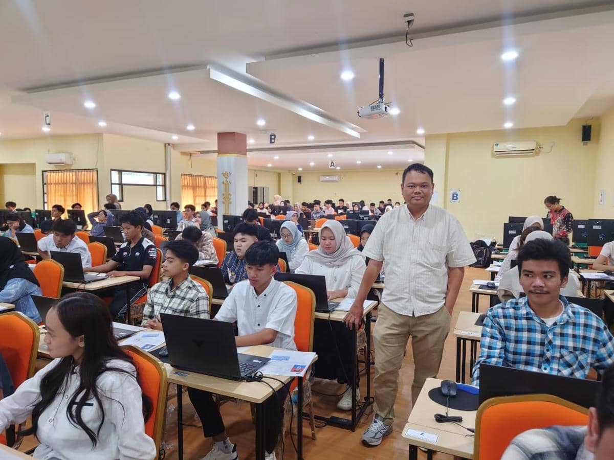 Peserta ujian Seleksi Mandiri Masuk Universitas Lampung 2026 mengerjakan tes berbasis komputer di ruang kelas dengan pengawas.