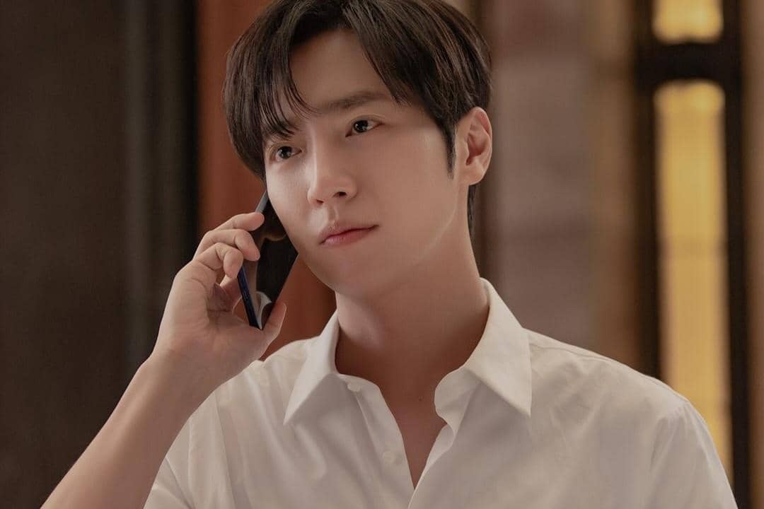 Seorang pria mengenakan kemeja putih sedang berbicara di telepon dalam adegan drama Dream to You.