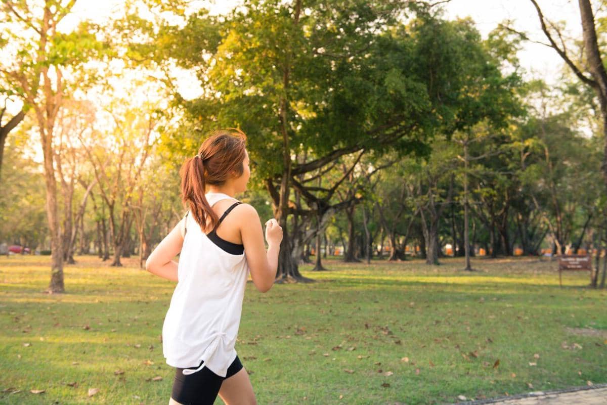 Ilustrasi seseorang sedang jogging di taman, berolahraga lari santai di area hijau terbuka yang asri.