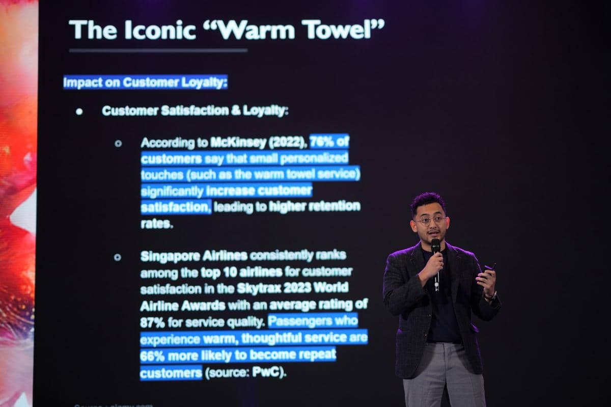 Seorang pembicara mempresentasikan materi bertema loyalitas pelanggan di acara ELSA Business yang kini berbasis kecerdasan buatan.