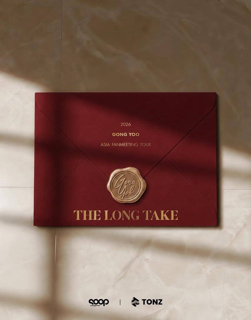 Amplop merah marun bertuliskan 'Gong Yoo 2026 Asia Fanmeeting Tour The Long Take' dengan segel lilin emas di atas permukaan marmer.