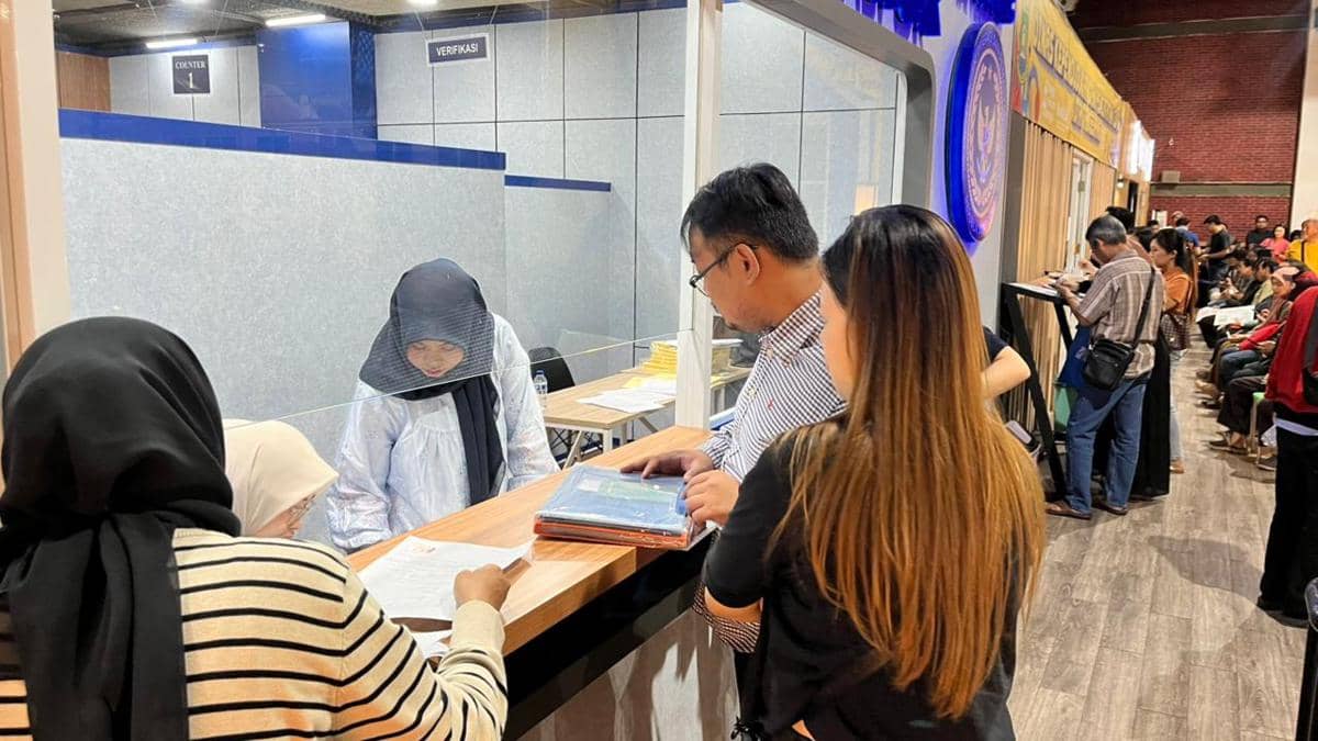 Warga mengurus dokumen paspor di loket pelayanan Kantor Imigrasi Tangerang dengan antrean masyarakat di area tunggu.