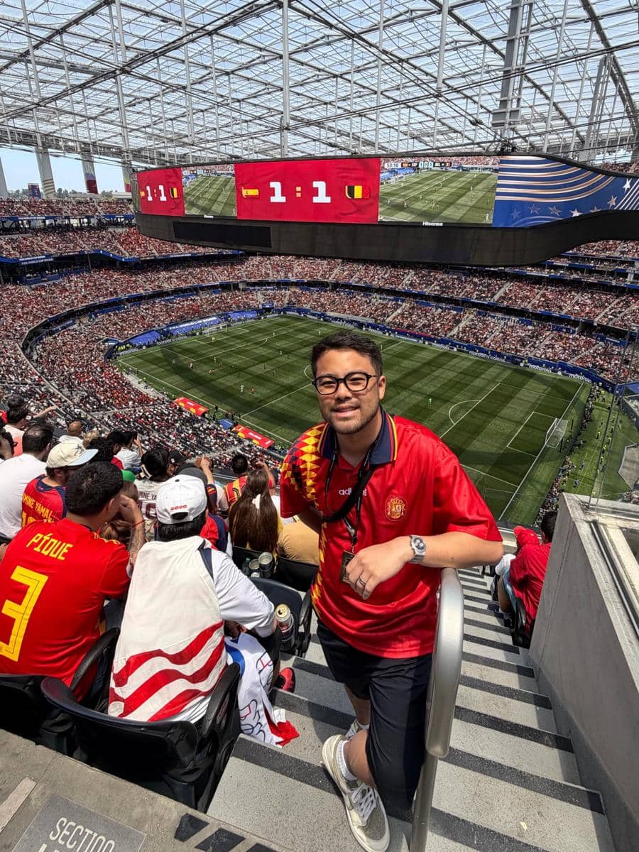 Seorang penonton mengenakan jersey tim Spanyol berpose di tribun stadion saat pertandingan Spanyol melawan Belgia dengan skor imbang 1-1.
