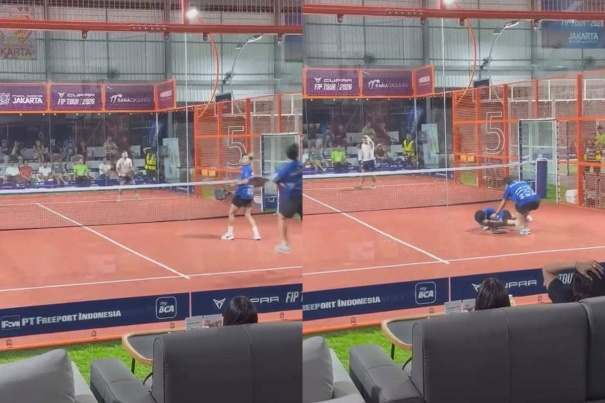 Seorang pemain padel terjatuh di lapangan setelah terkena bola saat pertandingan berlangsung di arena indoor dengan penonton di belakangnya.