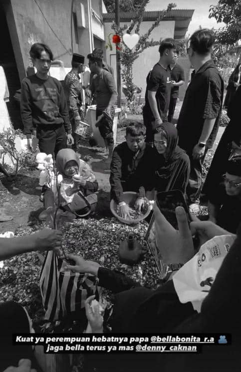 Sejumlah orang berpakaian hitam menghadiri pemakaman dan menabur bunga di atas makam, suasana duka terlihat di area pemakaman.