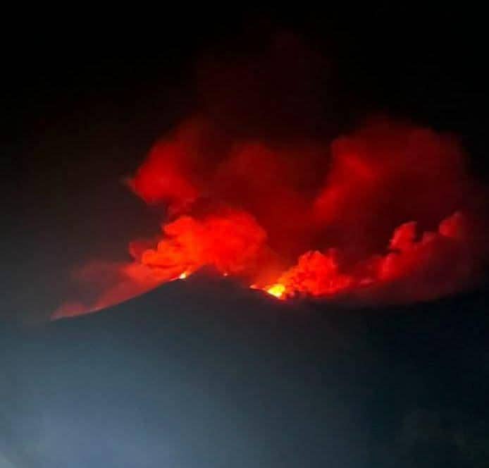 Erupsi Gunung Karangetang di Siau, Sulawesi Utara, memancarkan cahaya merah dan asap tebal pada malam hari terlihat dari kejauhan.