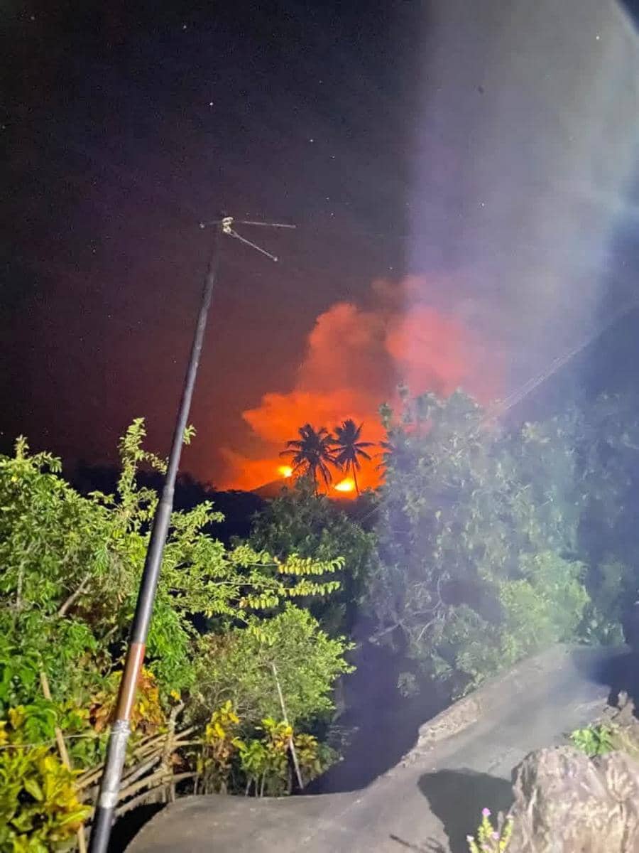 Erupsi Gunung Karangetang terlihat menyala di kejauhan pada malam hari dari kawasan perumahan warga di Siau, Sulawesi Utara.
