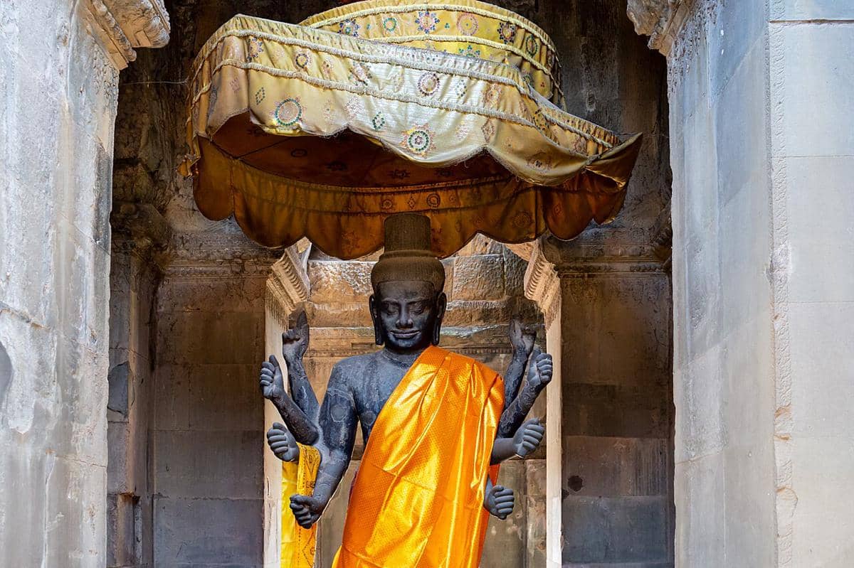 Patung Ta Reach, sebuah patung dewa Hindu Wisnu yang dihormati dengan delapan lengan. Letaknya di dalam ruang suci bagian dalam kompleks candi Angkor Wat di Kamboja.