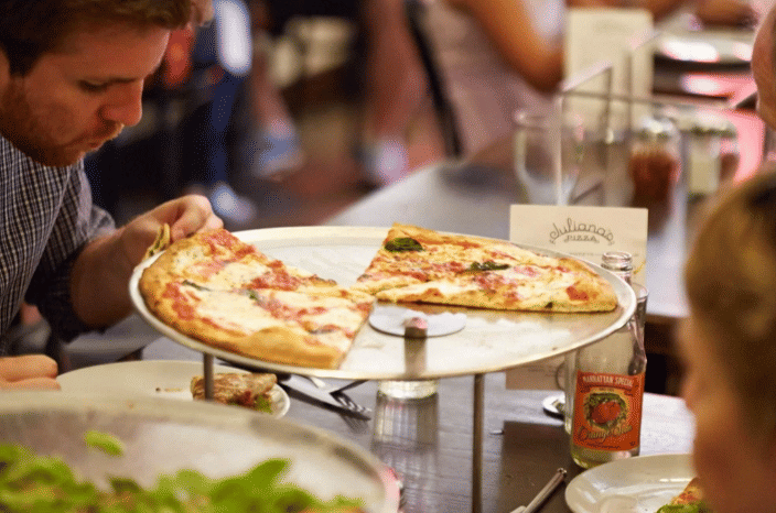 potret pelanggan menikmati pizza di Juliana's Pizza