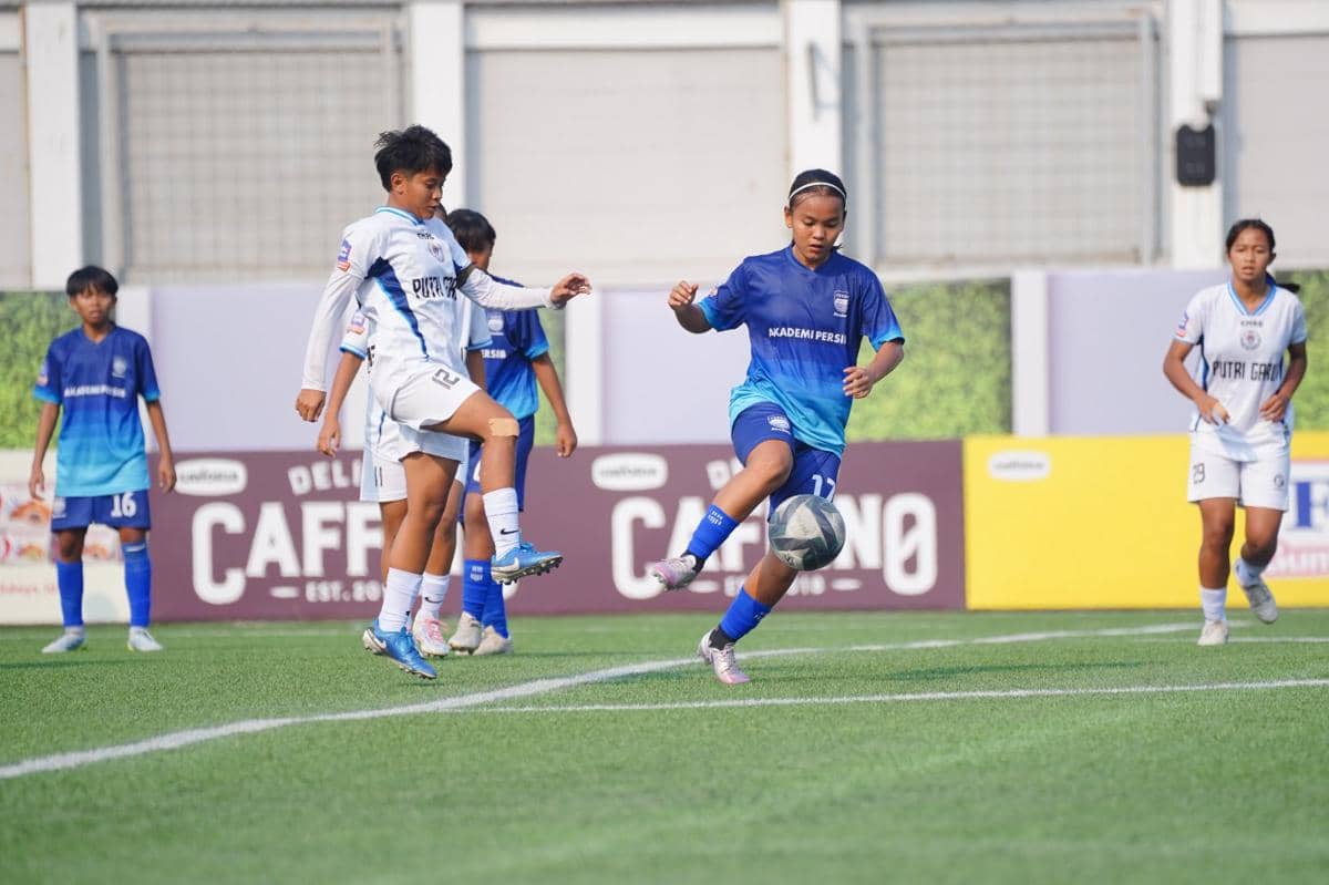 Pemain sepak bola wanita dari dua tim berseragam biru dan putih berebut bola di lapangan pada final Hydroplus Soccer League 2025/26.