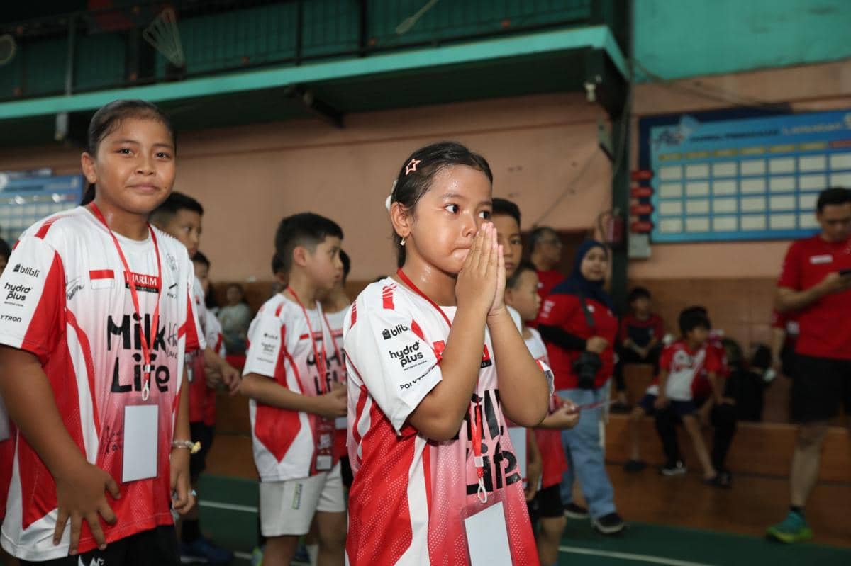 Anak-anak peserta Audisi Umum Djarum 2026 di Pekanbaru mengenakan seragam merah putih di dalam gedung olahraga dengan ekspresi tegang dan haru.