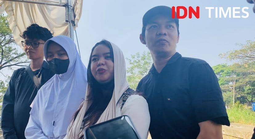 Beberapa anak Temon berdiri bersama di luar ruangan pada siang hari, sebagian mengenakan pakaian kasual dan hijab putih.