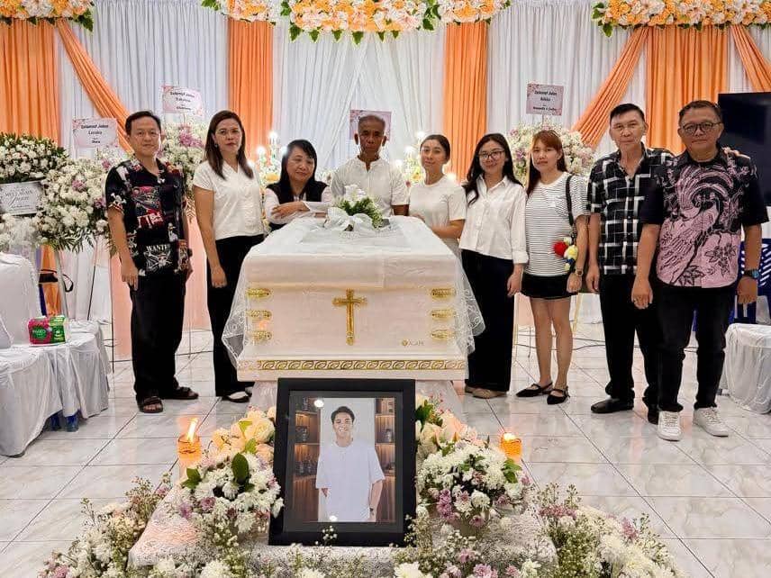 Sejumlah pelayat berdiri di sekitar peti jenazah berhias bunga dan salib emas dalam ibadah pemakaman di Manado.
