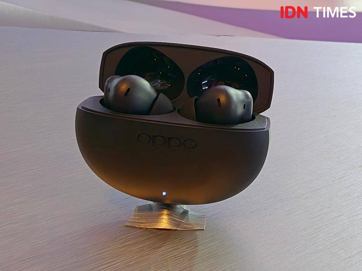 Earbud nirkabel OPPO Enco Air5 berwarna hitam dengan wadah pengisi daya terbuka diletakkan di atas permukaan meja.