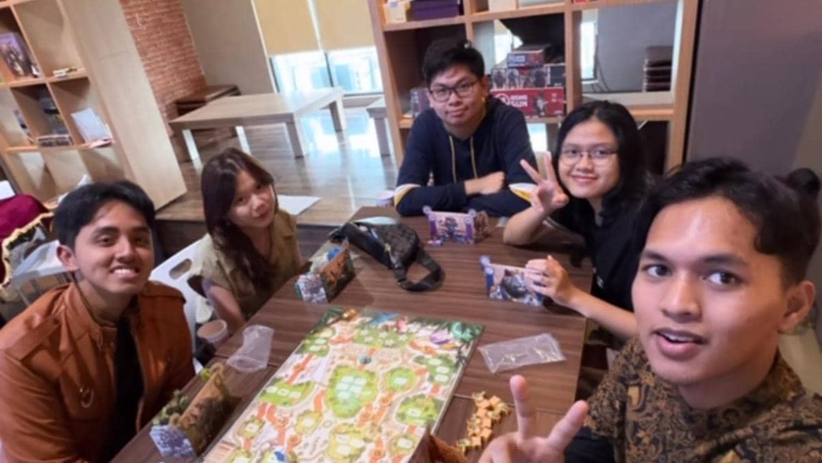 Lima peserta Clash of Champions Season 3 duduk bersama di meja bermain board game sambil tersenyum dan berpose santai.