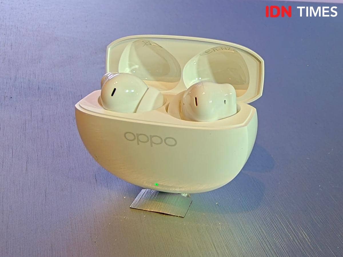 Earbud nirkabel OPPO Enco Air5s berwarna putih ditempatkan di dalam kotak pengisian daya dengan penutup terbuka di atas meja.