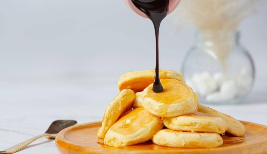 Ilustrasi pancake durian dengan lapisan cokelat, disajikan sebagai hidangan penutup bercita rasa manis dan lembut.