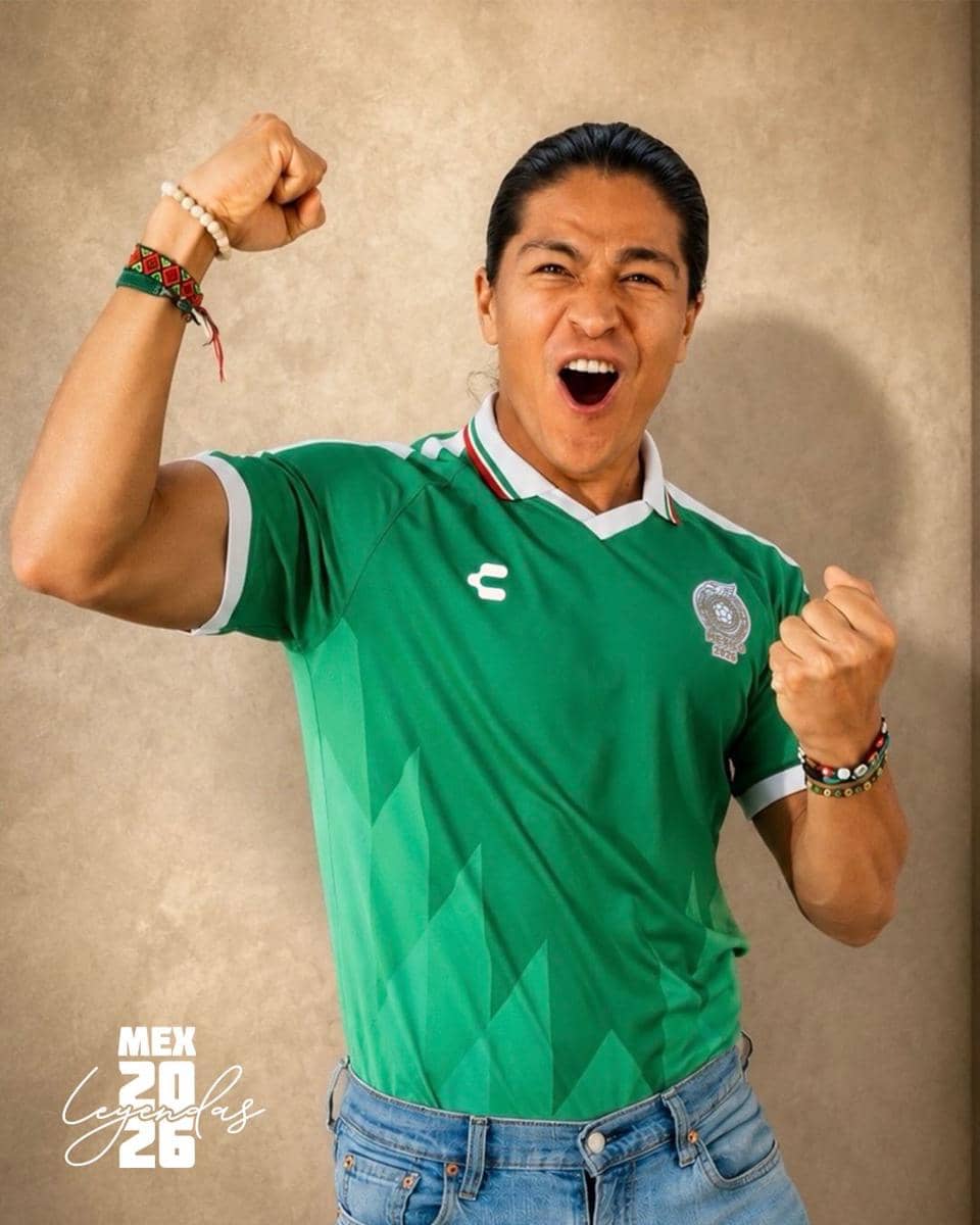 Seorang pria mengenakan jersey hijau tim nasional Meksiko, berpose dengan ekspresi semangat dan kedua tangan terkepal ke atas.