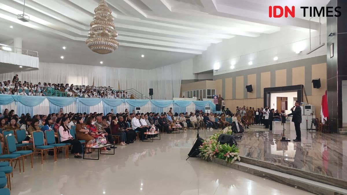 Seorang pembicara memberikan materi pelatihan AI di aula besar Kantor Gubernur Sulawesi Utara, Manado, di hadapan peserta yang memenuhi ruangan.