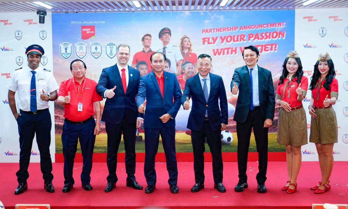 Perwakilan Vietjet dan ASEAN United FC berpose bersama dalam acara pengumuman kemitraan resmi di depan latar bertema sepak bola.