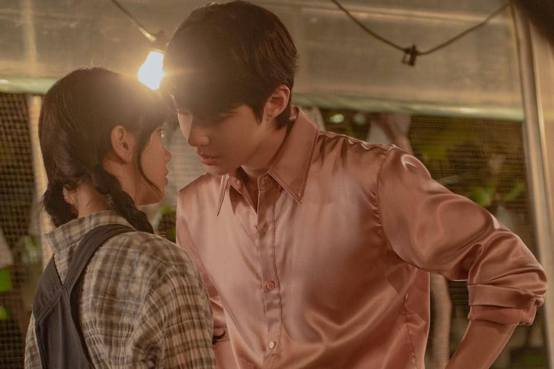 Dua karakter dalam drama Dream to You berdiri berhadapan dengan ekspresi tegang di bawah pencahayaan hangat malam hari.