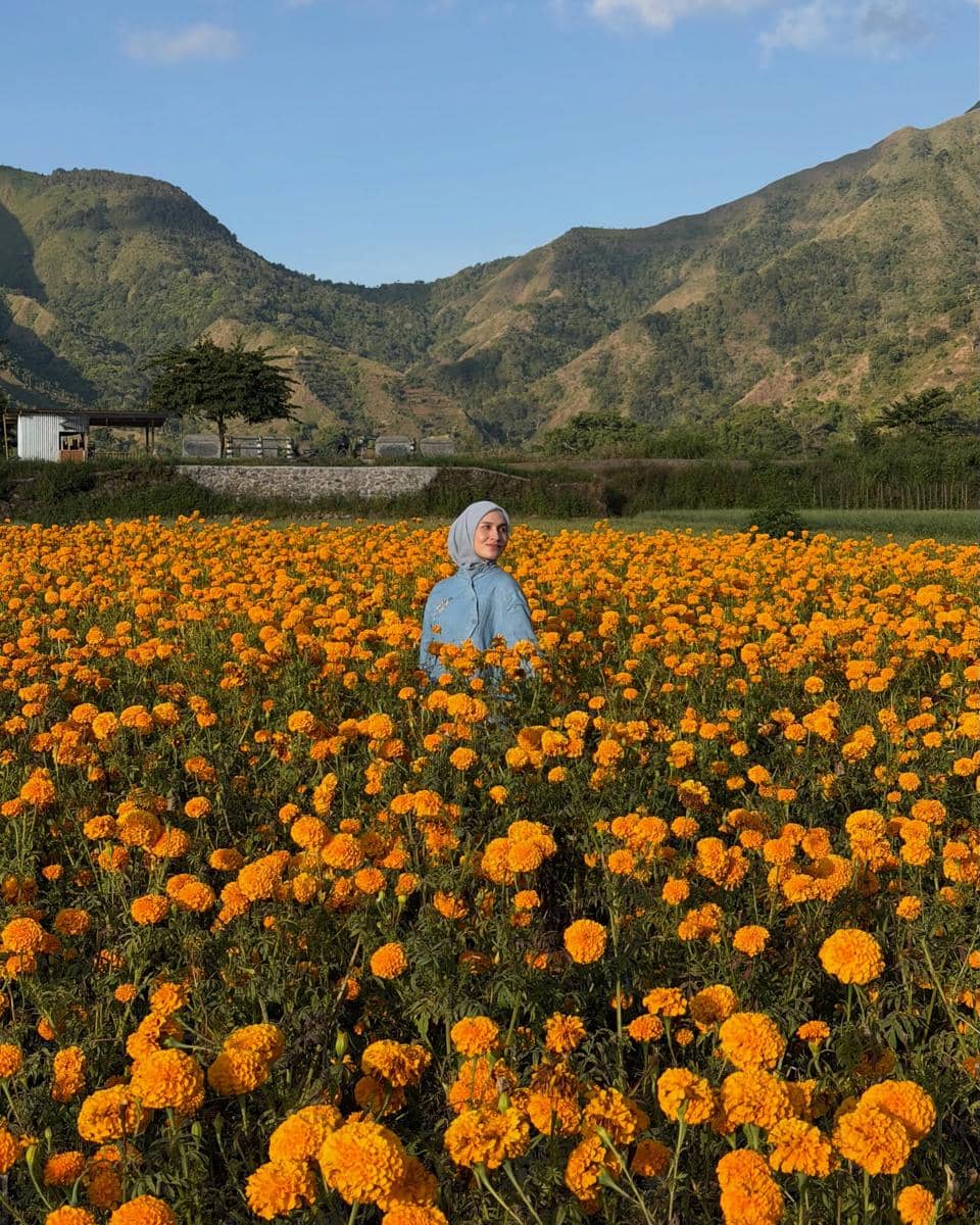 Dwi Handayani di tengah kebun bunga marigold di Desa Sembalun