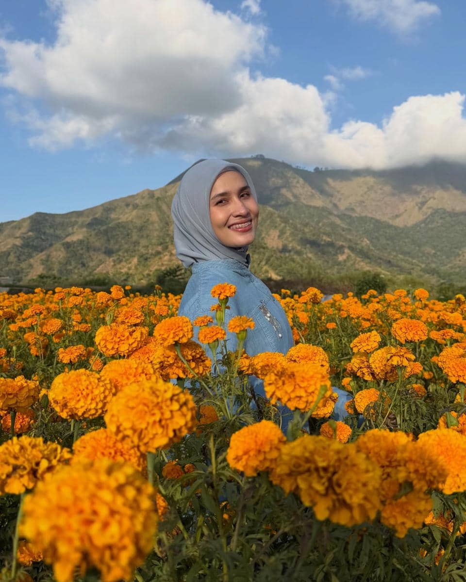 Dwi Handayani di tengah kebun bunga marigold di Desa Sembalun