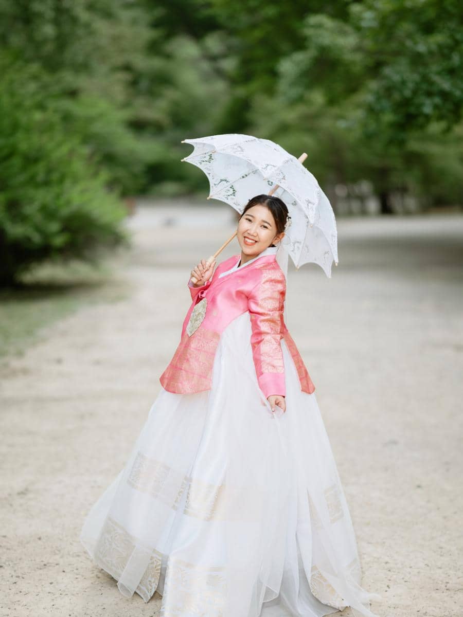 Kiky Saputri pakai hanbok pink saat di Gyeongbokgung Palace