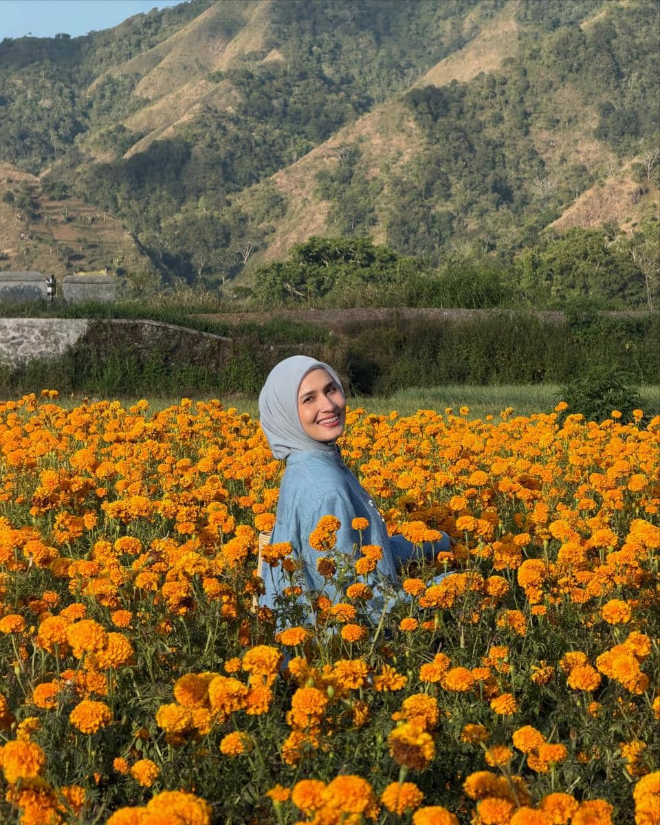 Dwi Handayani di tengah kebun bunga marigold di Desa Sembalun