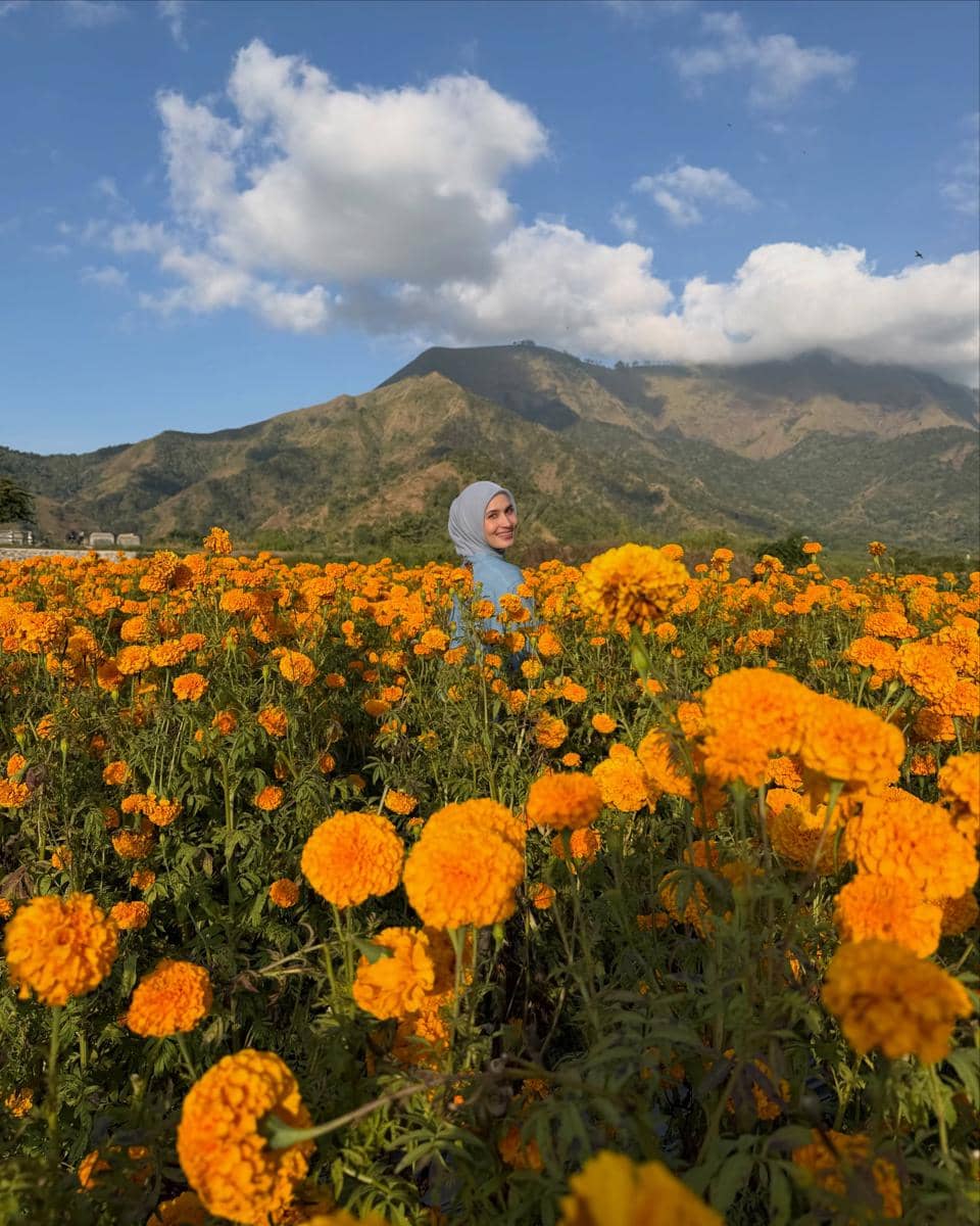 Dwi Handayani di tengah kebun bunga marigold di Desa Sembalun