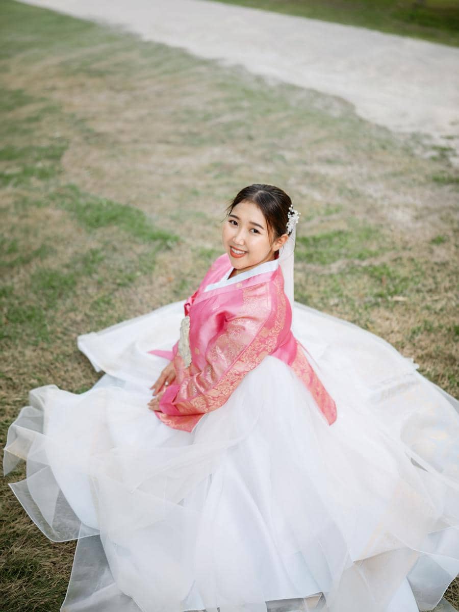 Kiky Saputri pakai hanbok pink saat di Gyeongbokgung Palace