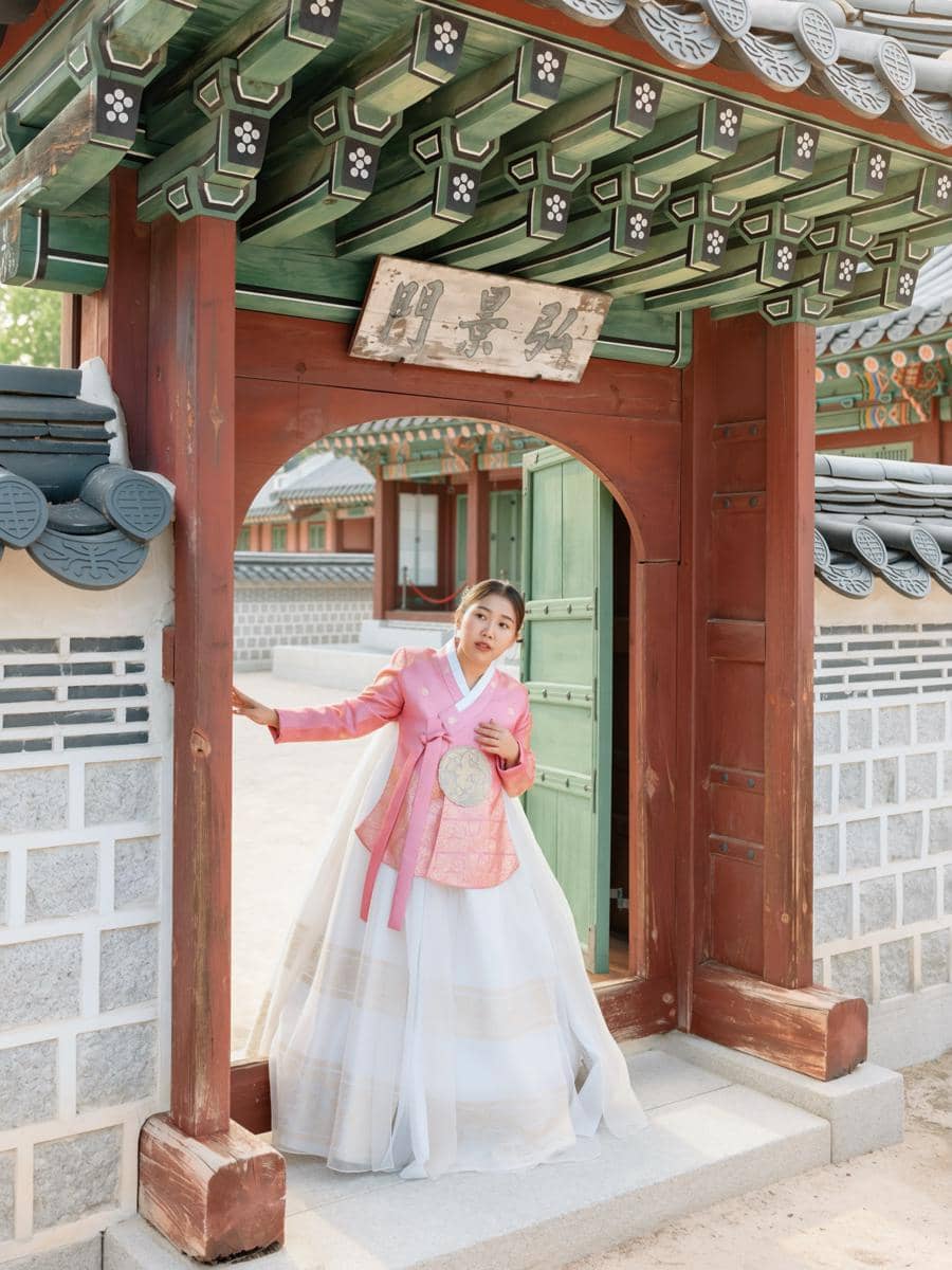 Kiky Saputri pakai hanbok pink saat di Gyeongbokgung Palace