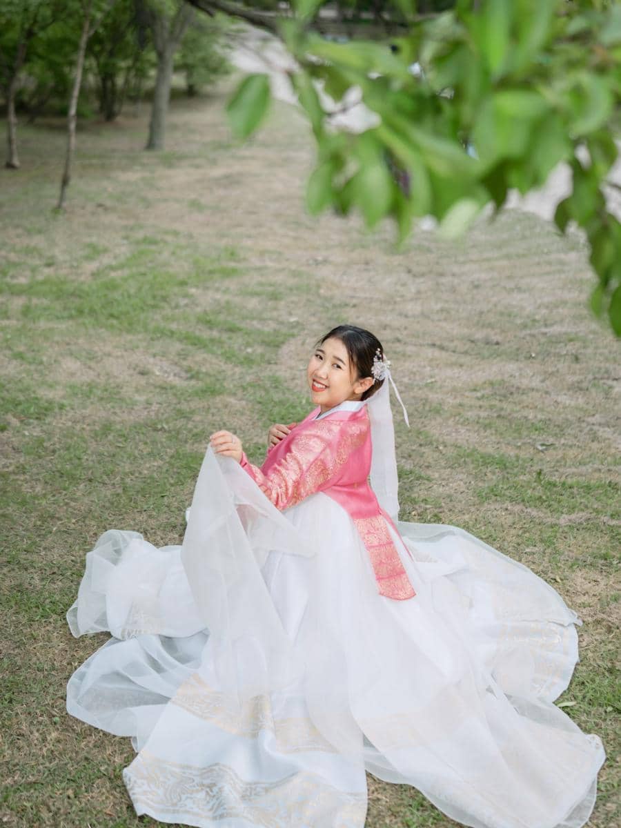 Kiky Saputri pakai hanbok pink saat di Gyeongbokgung Palace