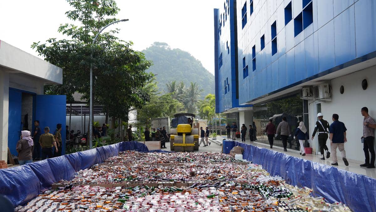 Petugas Bea dan Cukai Sumbagbar melakukan penindakan dengan alat berat untuk memusnahkan berbagai botol minuman ilegal di area kantor.